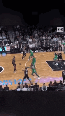 a basketball game is being played in a stadium with a b-r sign in the background