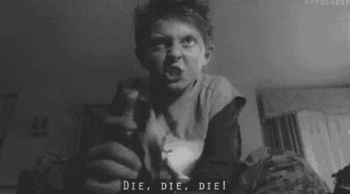 a black and white photo of a young boy screaming while holding a remote control .