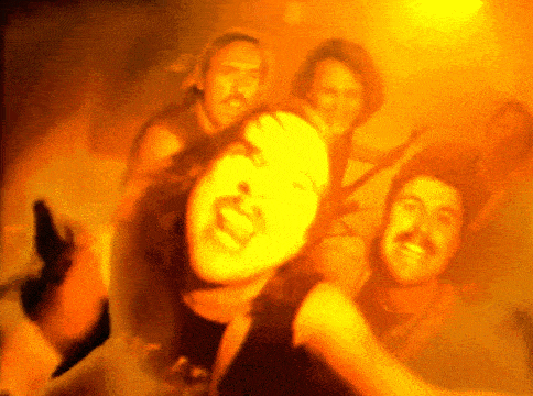 a group of people are dancing in a room with a yellow background