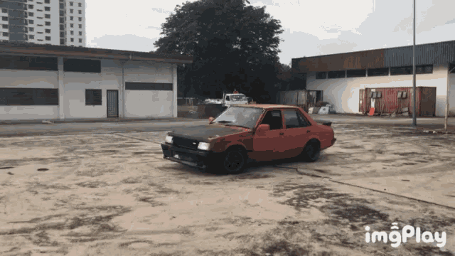 a red car is parked in a parking lot with the words imgplay on the bottom right