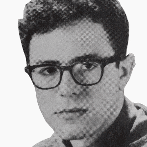 a young man wearing glasses looks at the camera