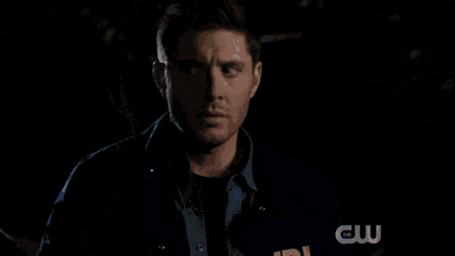 a man in a blue jacket is standing in front of a black background that says cool