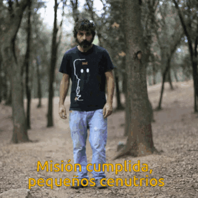 a man in a black shirt stands in a forest with the words mision cumplida pequenos cenutrios written in yellow