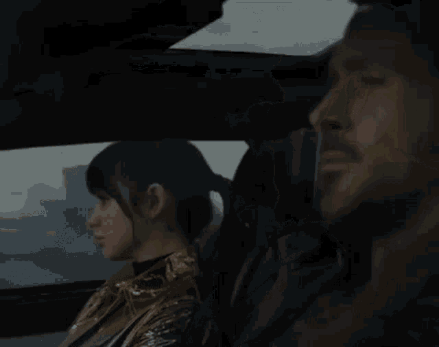 a man with a beard is sitting in the back seat of a car .