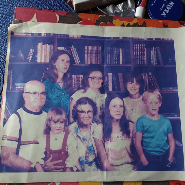 a picture of a family taken in front of a bookshelf with nivea cream