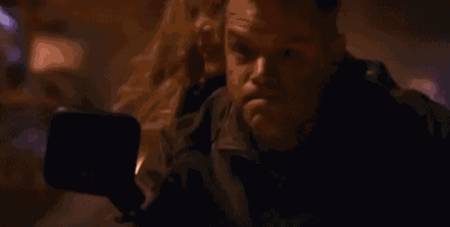 a man and a woman are riding a motorcycle in a dark room .