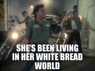 a man is standing in front of motorcycles with the words she 's been living in her white bread world