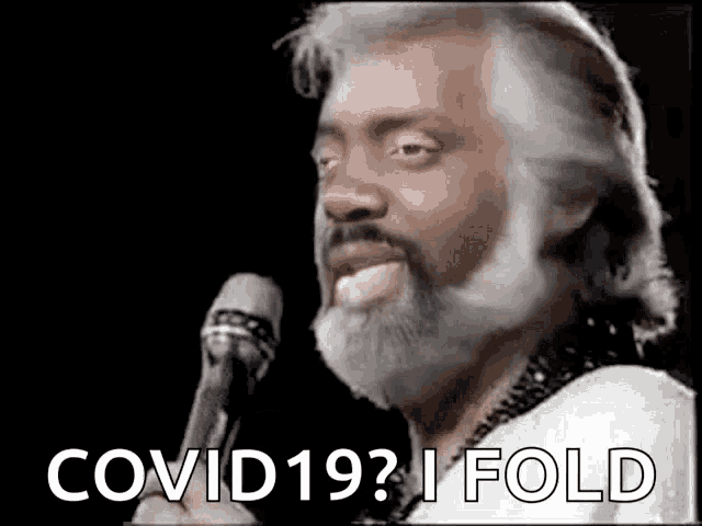 a man with a beard is singing into a microphone and says `` covid19 ? i fold '' .