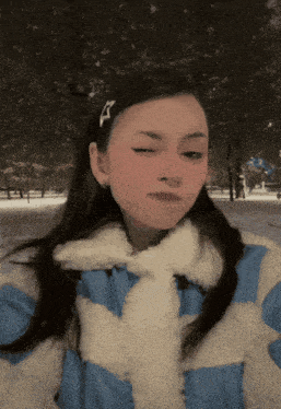 a girl wearing a blue and white coat with a white collar