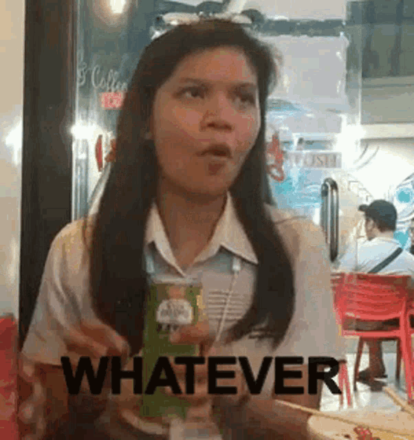 a woman is sitting at a table holding a can of pringles and the word whatever is on the bottom