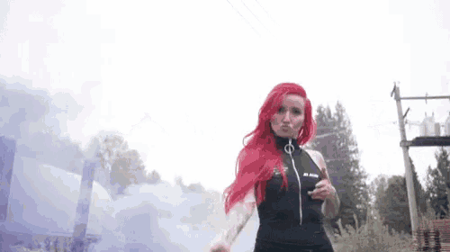 a woman with red hair is wearing a black top with the letter o on it