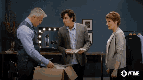 three people are standing in front of a box that says showtime
