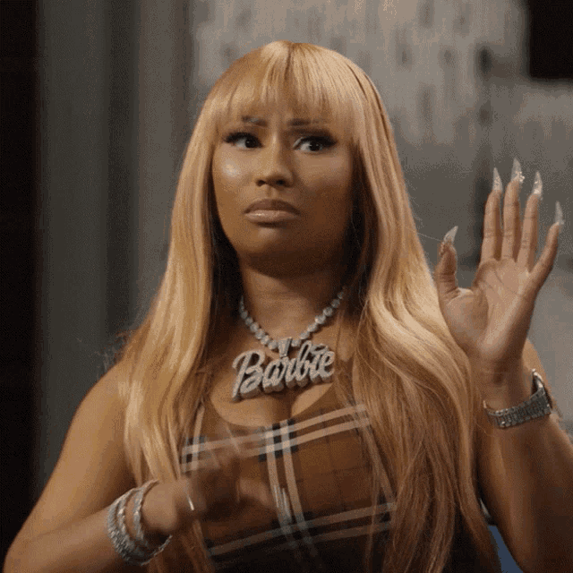 a woman wearing a plaid top and a barbie necklace