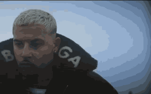 a man wearing a black jacket with the word balenciaga on the collar