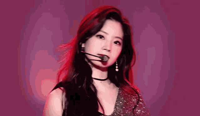 a close up of a woman wearing a choker and a microphone on a stage .