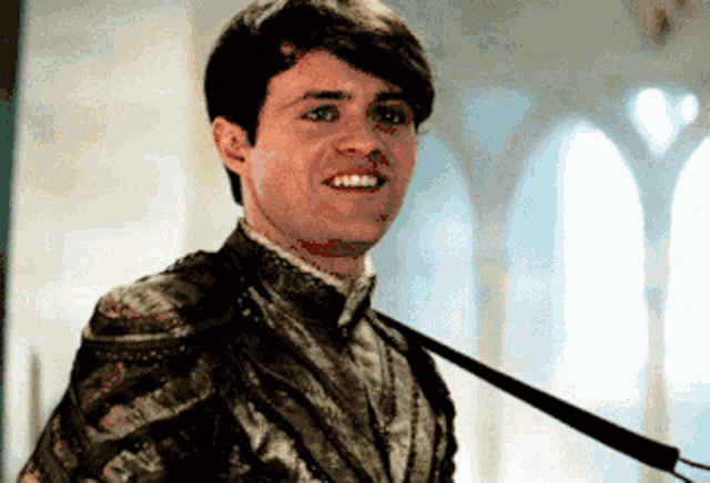 a man with a sword around his neck smiles for the camera