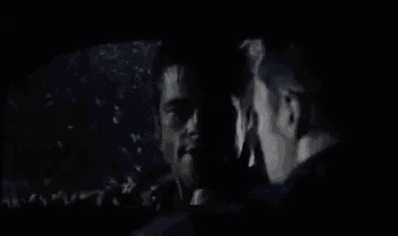 two men are standing next to each other in a dark room with the words `` let 's go '' .