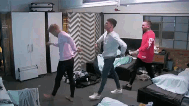 a group of young men are dancing in a room with a chevron wall .