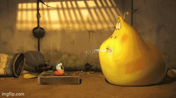 a yellow cartoon character is sitting on a table next to a book .