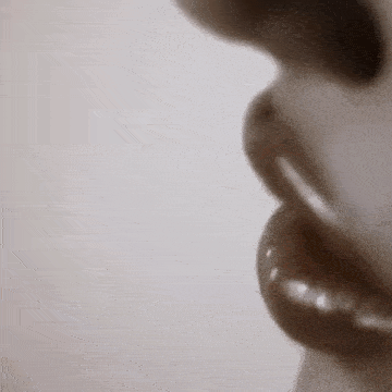 a close up of a woman 's mouth with a pearl ring .