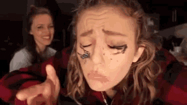 a woman with makeup on her face is making a face