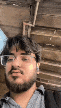 a man with a beard wearing glasses and a backpack