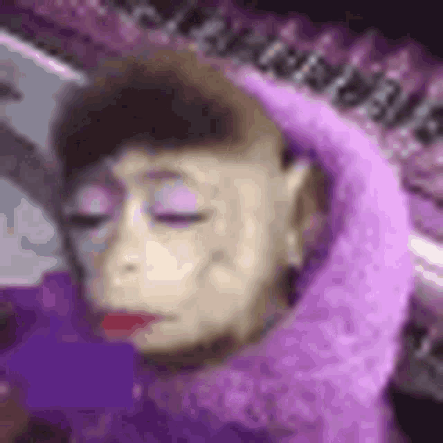 a close up of a monkey wearing a purple scarf and makeup .