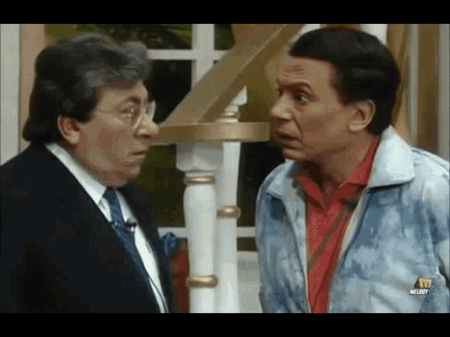 two men are standing next to each other and one of them is wearing a jacket that has the letter m on it