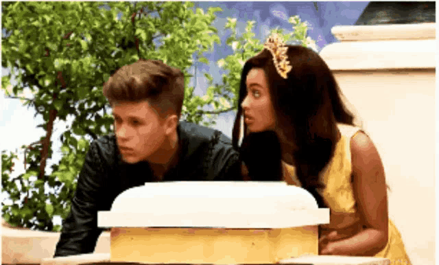 a boy and a girl are looking at a box