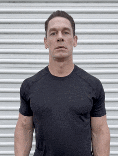 a man in a black t-shirt is standing in front of a white garage door