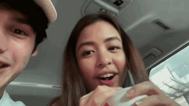 a man and a woman are sitting in the back of a car