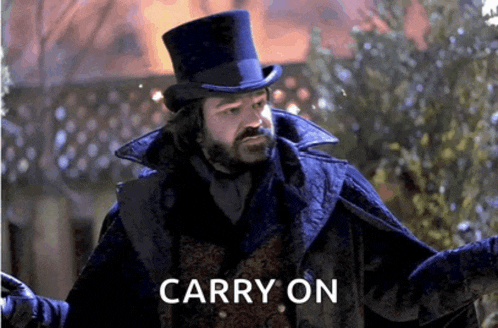a man wearing a top hat and a cape says carry on