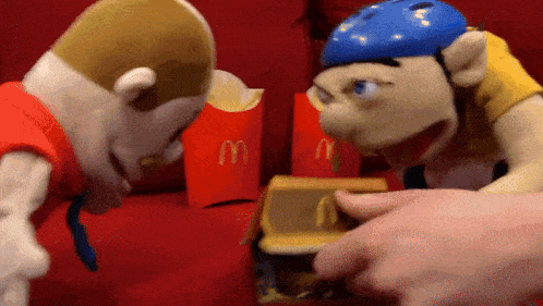 two stuffed animals are standing next to a mcdonald 's bag