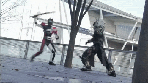 a man in a mask is fighting another man with a sword in front of a building .
