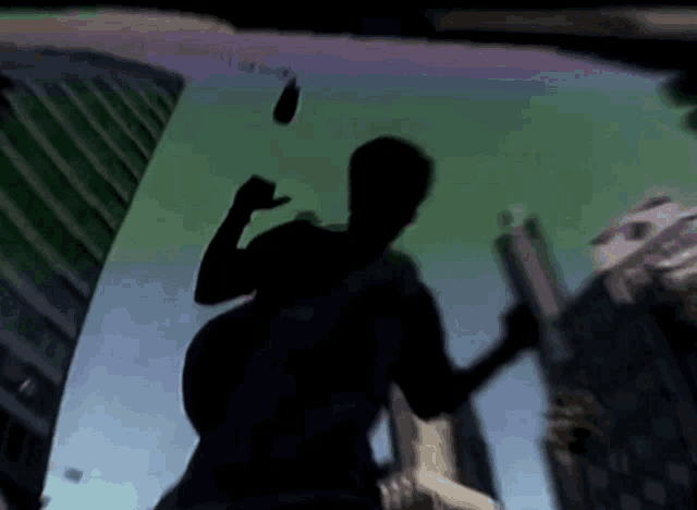 a silhouette of a man holding a gun in front of a building