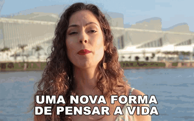 a woman stands in front of a body of water with the words uma nova forma de pensar a vida below her