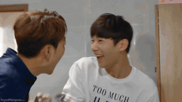a man wearing a white shirt that says too much on it