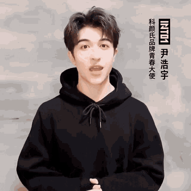a young man wearing a black hoodie with the word into on the bottom right