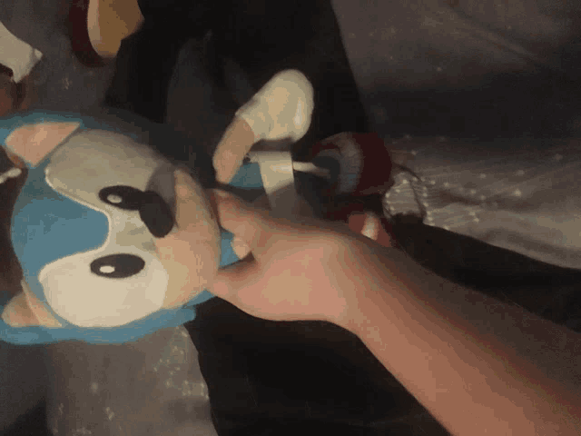 a person holding a stuffed sonic the hedgehog toy