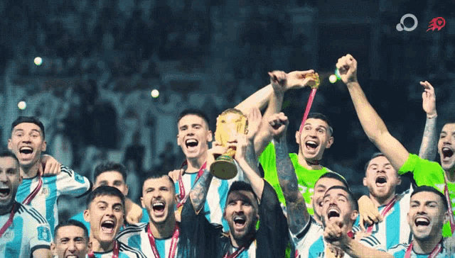 a group of soccer players celebrate with a trophy in the air