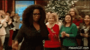 a woman with curly hair is dancing in front of a crowd .