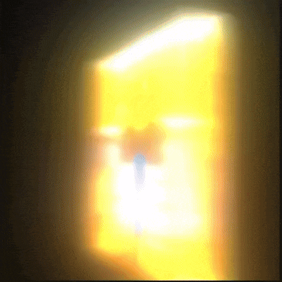 a blurred image of a person standing in front of a yellow light