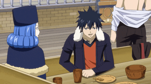 a man and a woman are sitting at a table with plates and cups