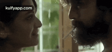 a man and a woman are looking at each other and kissing .