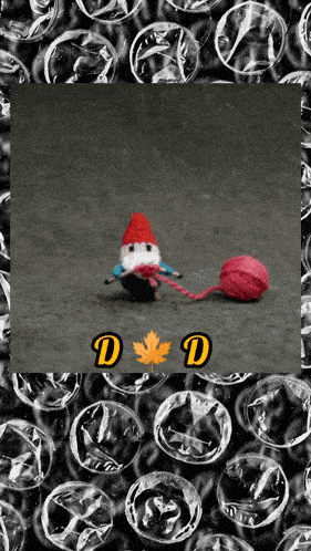 a picture of a gnome holding a ball of yarn with the letter d on the bottom