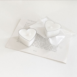 two heart shaped candles are on top of a piece of paper