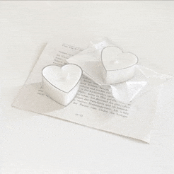 two heart shaped candles are on top of a piece of paper