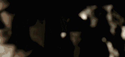 a man is standing in a dark room looking at something .