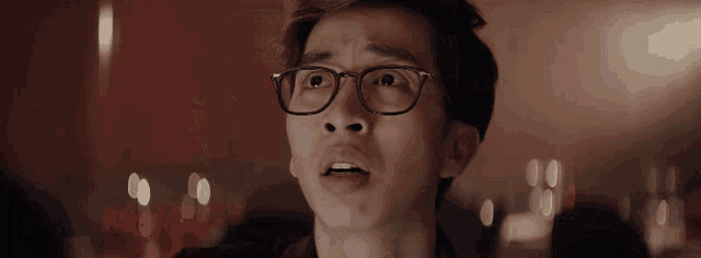 a man wearing glasses looks surprised at something