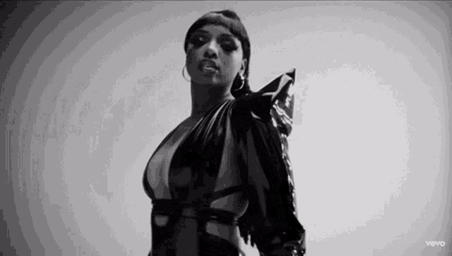 a black and white photo of a woman wearing a very revealing black dress .